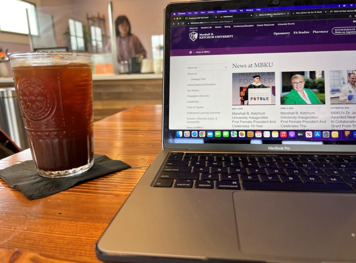 Photo of coffee next to a laptop