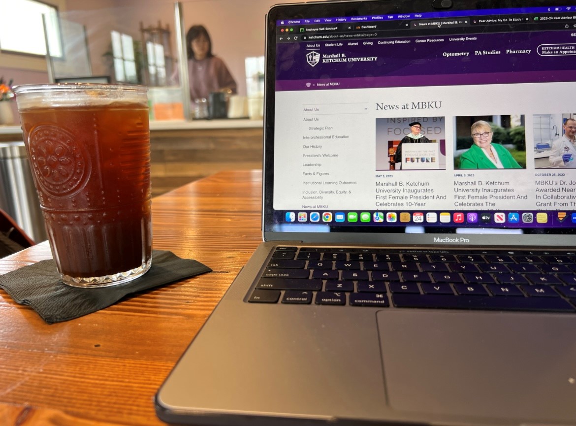 Photo of coffee next to a laptop