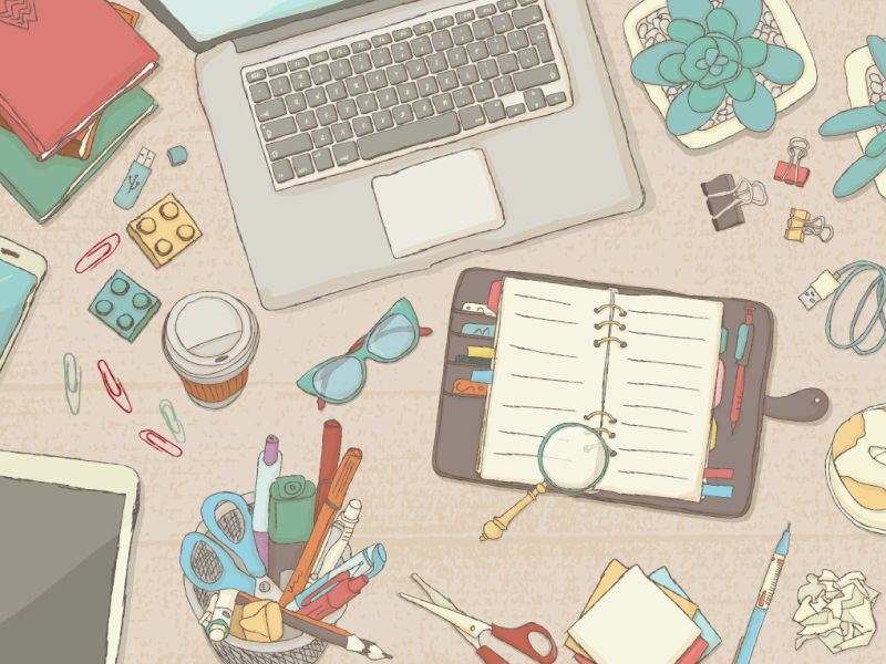 An illustration of a items scattered on a desk surrounding a laptop and notebook.