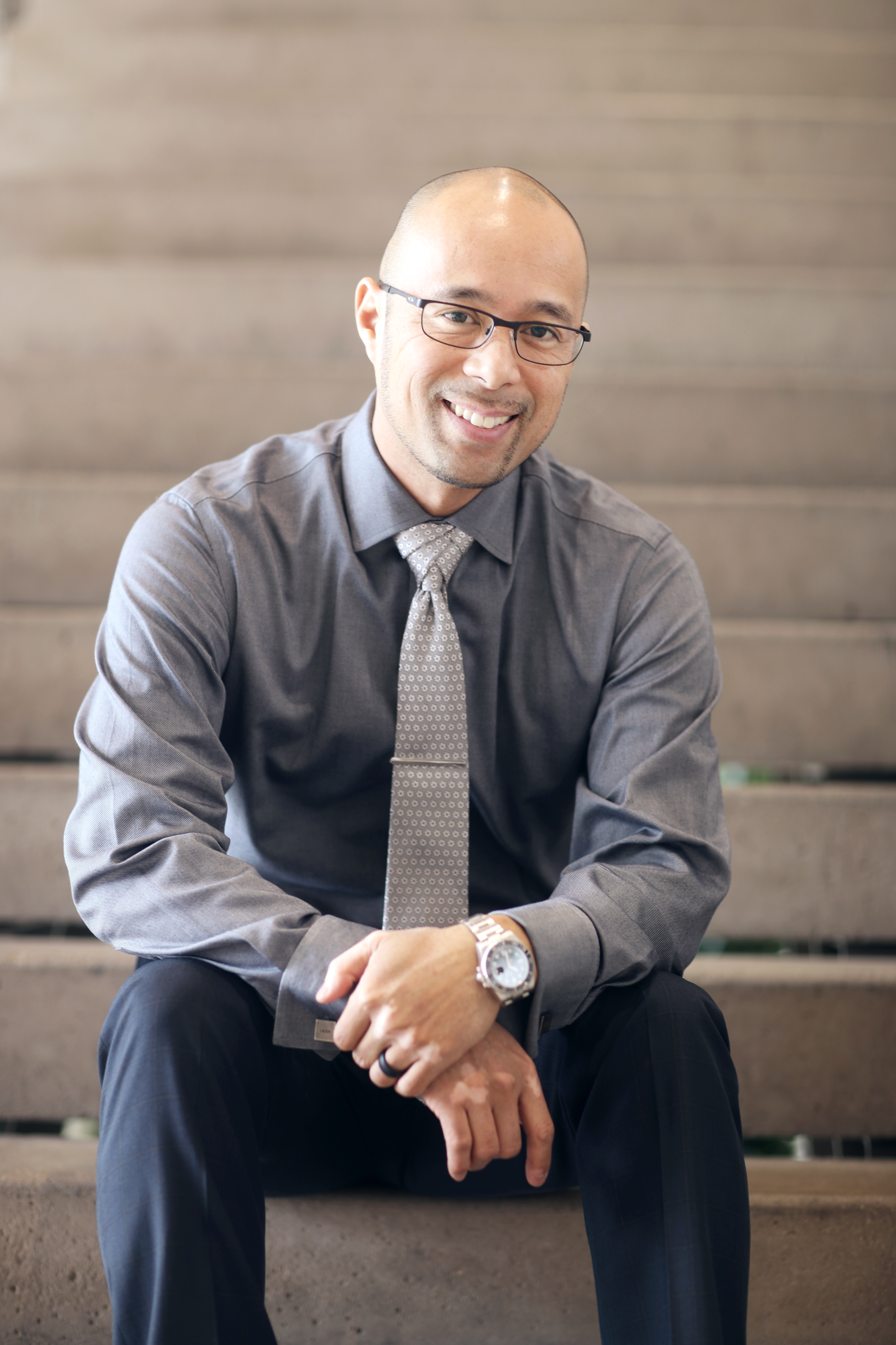 Dr. Elvin Hernandez smiling and sitting on stairs