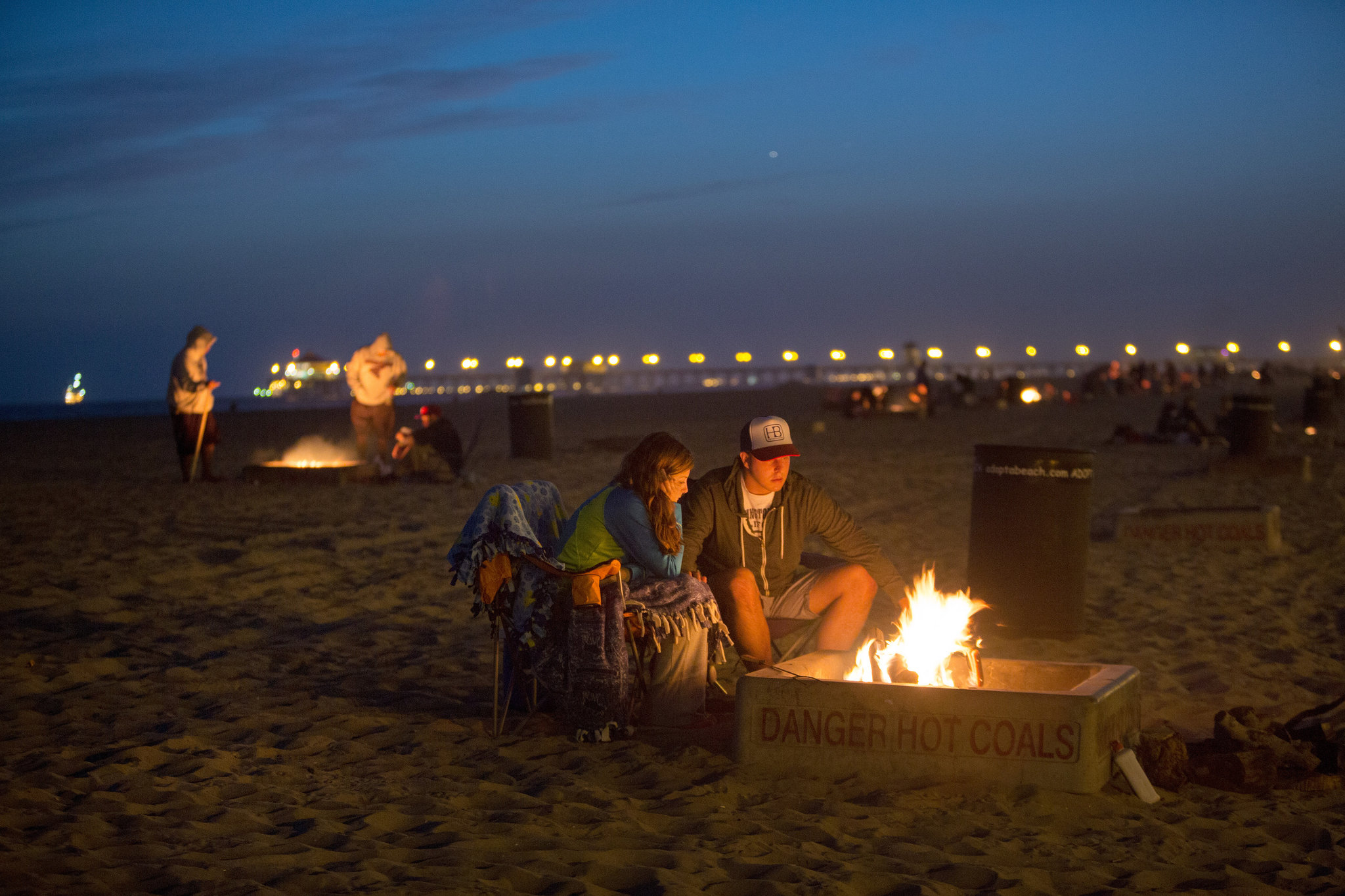 Photo of couple around a bonfire on the beach