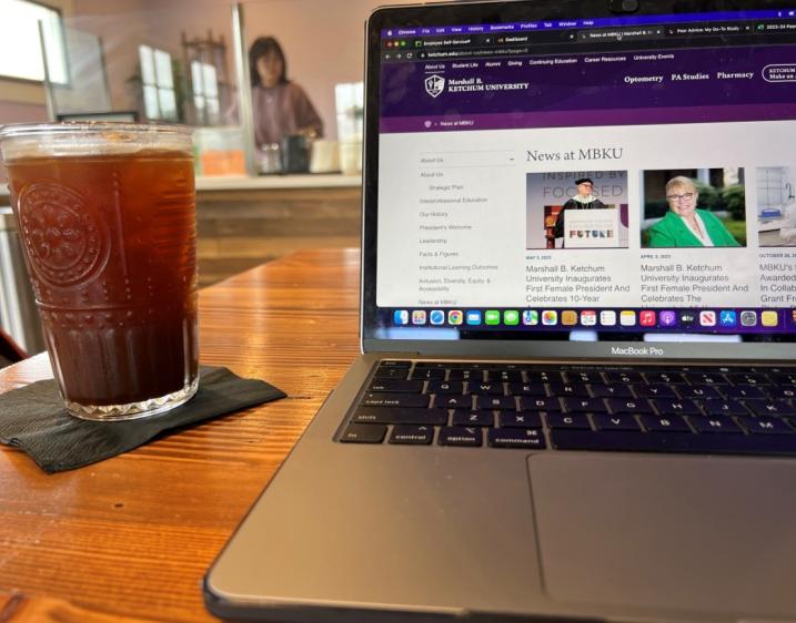 Photo of coffee next to a laptop