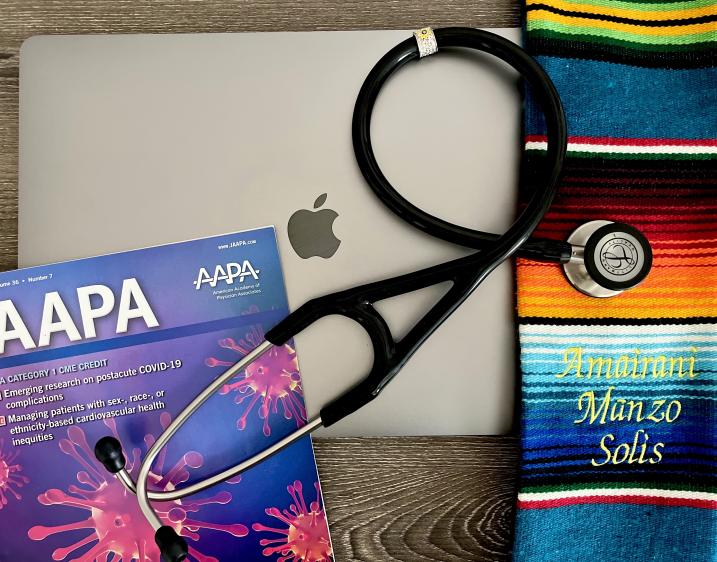 Image of a closed laptop with a stethoscope, JAAPA journal and graduation cords on top