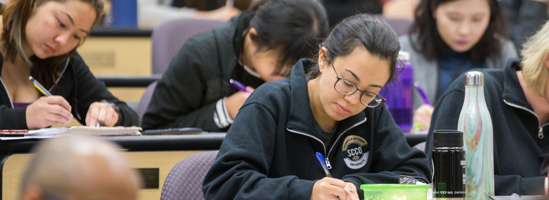 Optometry students taking notes during lecture